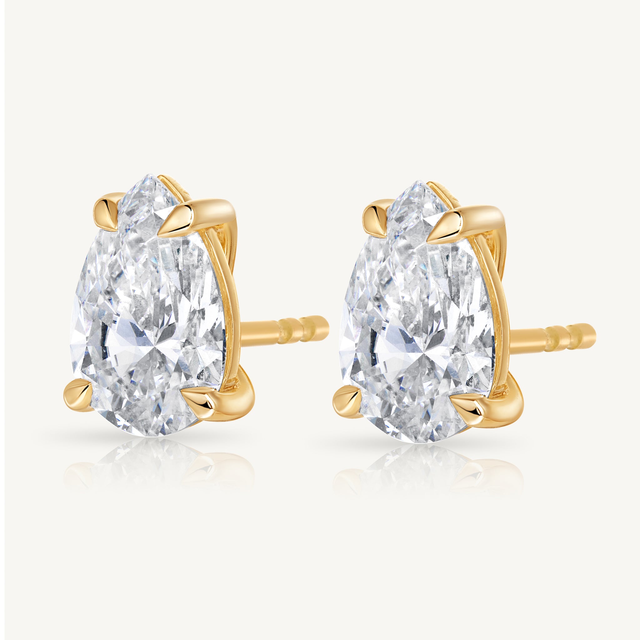 A pair of pear-cut diamond stud earrings in yellow gold prong settings Harlow George Jewelry