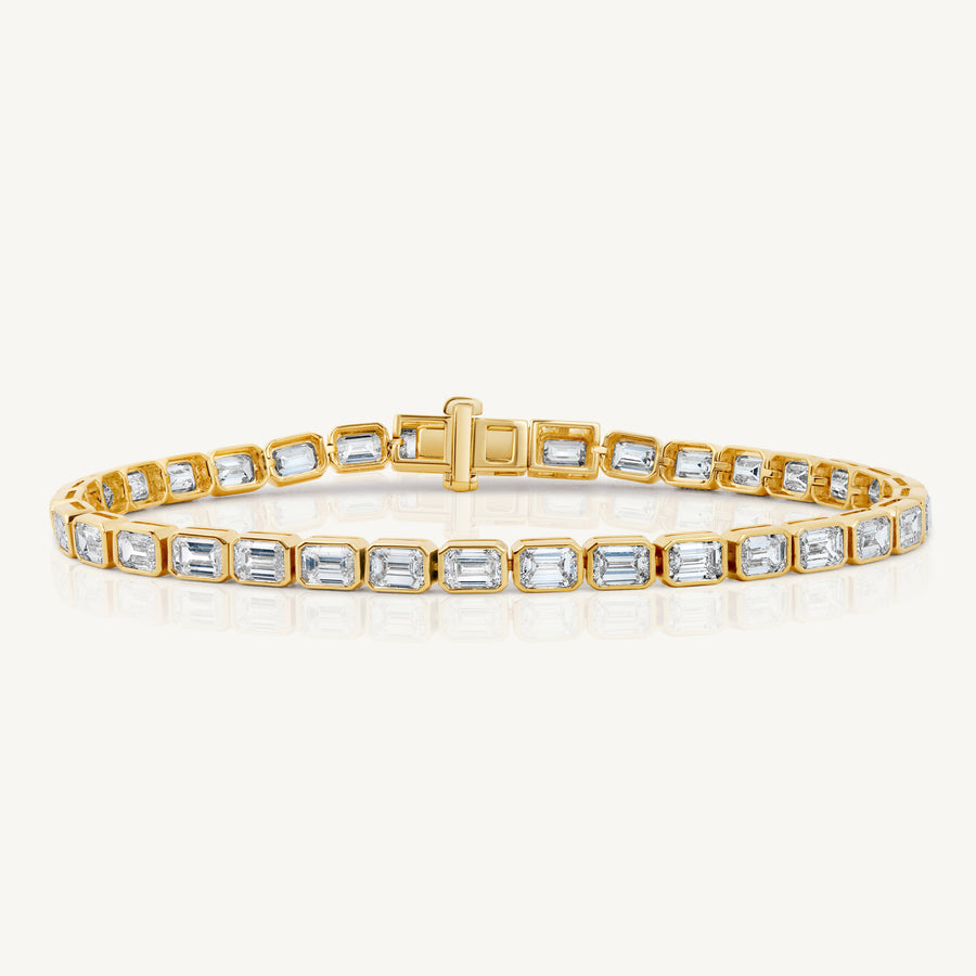 A yellow gold east west emerald cut diamond tennis bracelet by Harlow George